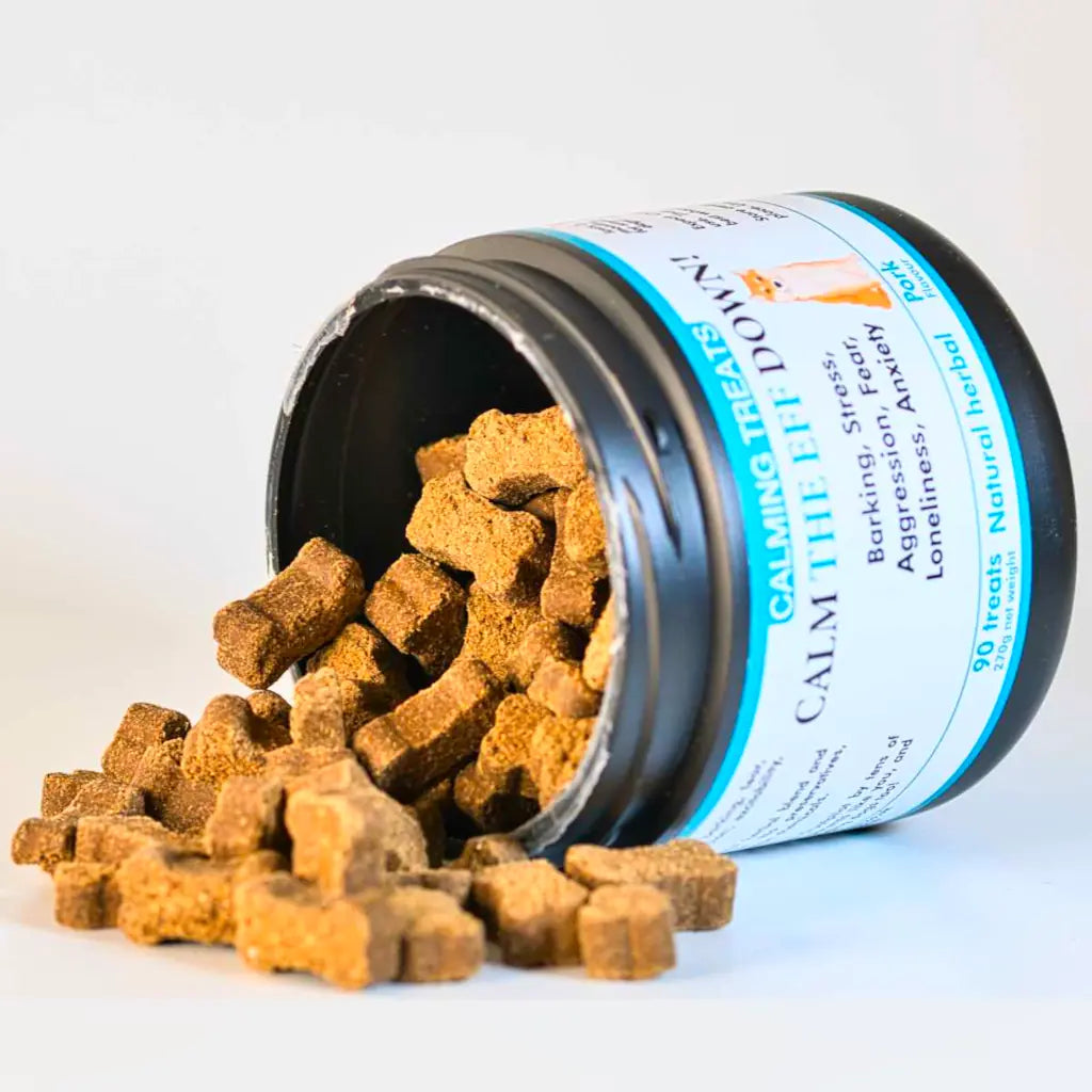 Jar of 'Calm The Eff Down!' calming treats for dogs with a black lid and white label. On it's side. Treats spilling out.