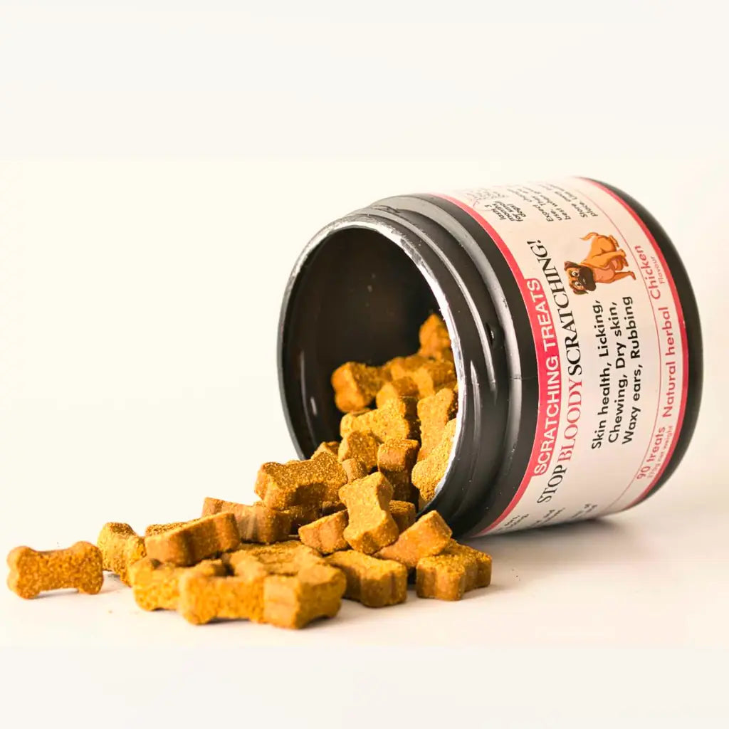 Jar of 'Stop Bloody Scratching' treats for dogs with a black lid and white label.Jar is on it's side. Treats are spilling out.
